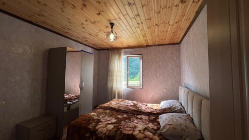 a bedroom with a bed and a wooden ceiling at Cozy Corner Inn in Ushkhvanari