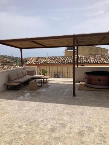 a pavilion with a couch and a table on a roof at Casa Fioraliso in Noto