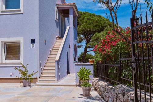 a blue house with stairs and flowers at Apartmani Raić in Mali Lošinj