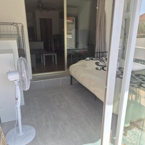 a bedroom with a bed with a fan and a mirror at Studio avec grande terrasse in Carnon-Plage