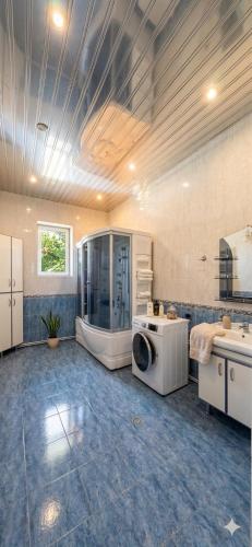 a large bathroom with a shower and a washing machine at Elkasa guest house in Zvartnots International Airport