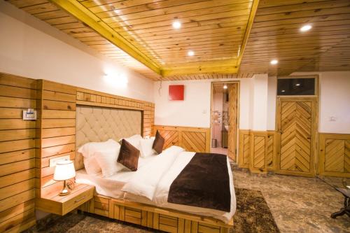 a bedroom with a large bed in a room with wooden walls at AYUSHKAMA COTTAGE #Naddi Sunset Point#Free Parking#cricket stadium8 km#Mcleodganj 2 km- Bhagsunag 4 km in Dharamshala