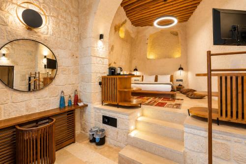 a bedroom with a bed and a mirror at Luvi Cave Hotel in Göreme