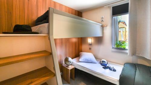 a small room with a bed and a window at Vic's Land Holidays in Grimaud
