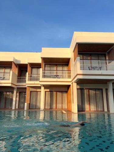 a swimming pool in front of a building at Sea Suphan Villa in Ban Hua Phrong