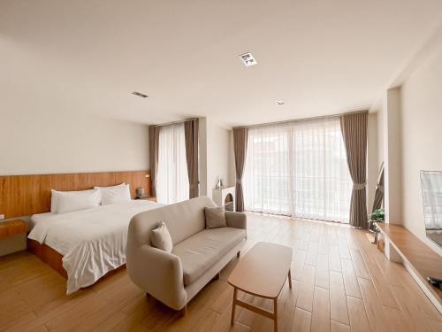 a bedroom with a bed and a chair and a couch at Sea Suphan Villa in Ban Hua Phrong