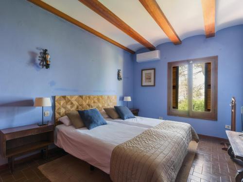 a bedroom with a large bed with blue walls at Finca Fuente Laurel in Arucas