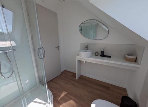 a white bathroom with a sink and a mirror at la clé de la rance in Plouër-sur-Rance
