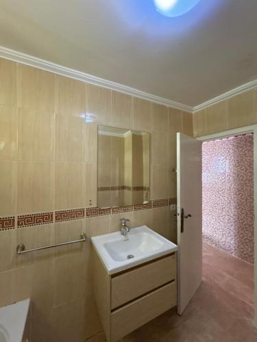 a bathroom with a sink and a mirror at Piscine, plage et relaxation in Pont Blondin