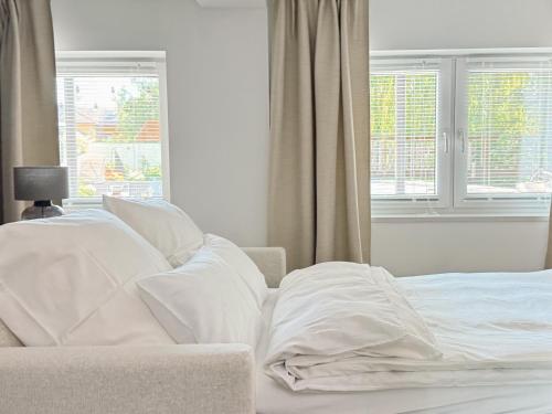 a bed with white sheets and pillows next to a window at Studio Bachgeflüster in Schattendorf
