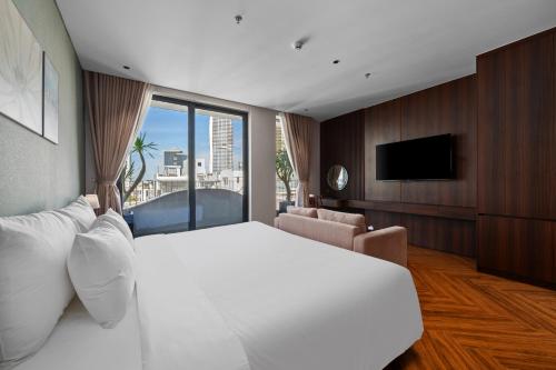 a hotel room with a large bed and a television at MAIA Boutique Hotel Da Nang in Danang