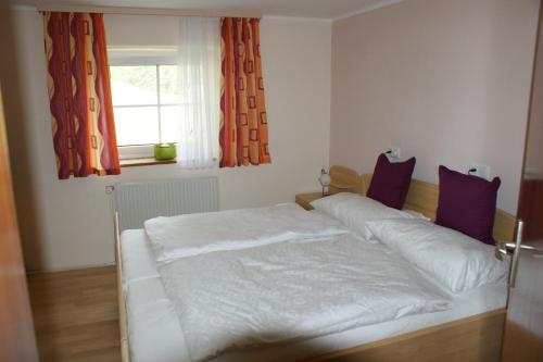 ein weißes Bett in einem Zimmer mit Fenster in der Unterkunft Schlagerberg in Scharnstein