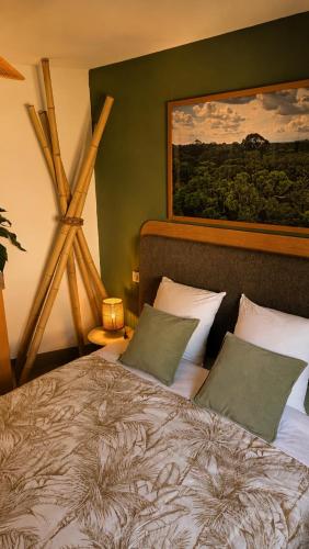 a bedroom with a bed and a painting on the wall at Maison atypique médiévale in Saint-Léonard-de-Noblat