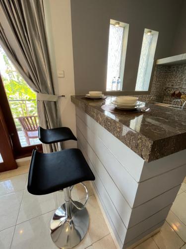 a kitchen with a counter and a black chair at Surya Guest House Sanur in Sanur
