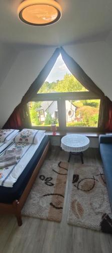 a bedroom with a bed and a large window at Agrodomki Okej - Dom Oleńka in Gardna Wielka