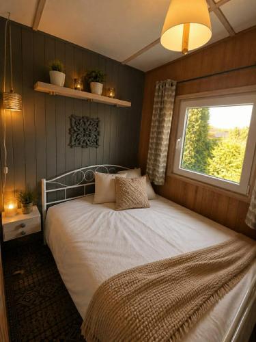 a bedroom with a large bed with a window at Domek Panorama in Rymanów-Zdrój