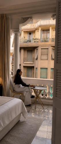 a woman sitting in a chair on the balcony of a building at Qasr court in Cairo