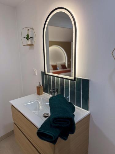 a bathroom with a sink with a green towel on it at Les arches in Riom