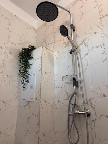 a shower in a bathroom with a stone wall at SummerBlue - Синьо лято in Lozenets