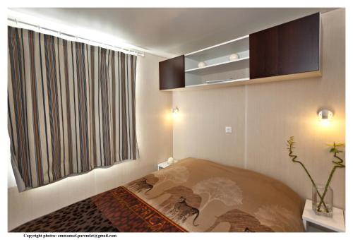 a bedroom with a bed and a large window at Vic's Land Holidays in Grimaud