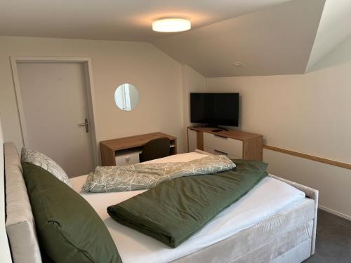 a bedroom with two beds and a flat screen tv at Fuchs at home in Kaltbrunn