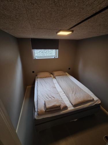 a bed in a small room with a window at Lofoten Apartment 01 in Leknes