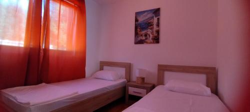 two twin beds in a room with a window at Tamaris apartments Risan in Risan