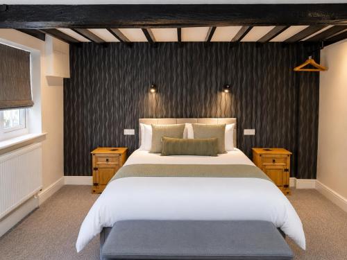 a bedroom with a large bed and a black wall at The George and Dragon Inn in Long Melford