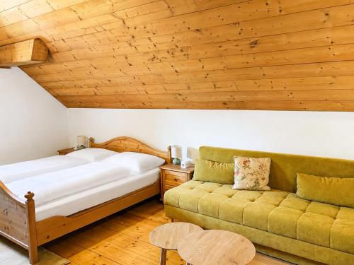 a bedroom with a bed and a couch at Landhaus Sisi - River&Pool in Bad Ischl