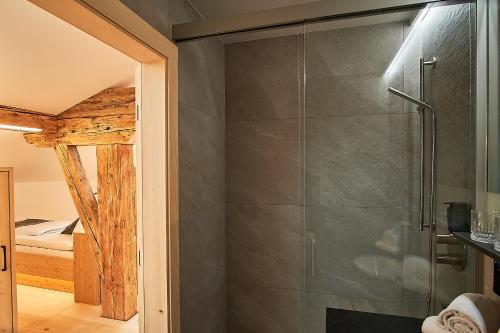 a shower with a glass door in a bathroom at Forsthaus Valepp in Schliersee