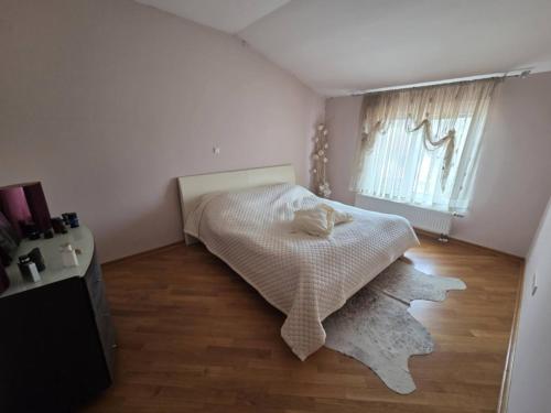 a small bedroom with a bed and a window at Apartment Emir in Mostar