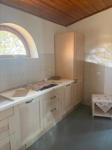 a kitchen with white cabinets and a window at Villetta Darsena con piscina gratuita dal 18 Luglio al 30 Agosto in Vulcano