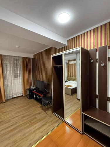 a room with a mirror and a room with a bedroom at Asia Hotel in Târgu Jiu
