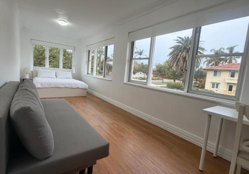 a white room with a bed and windows at Como Beach Apartment 2 in Perth