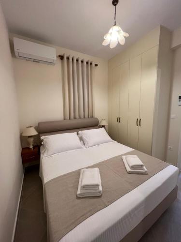 a bedroom with a large bed with two towels on it at Orizon Sea View in Vathi