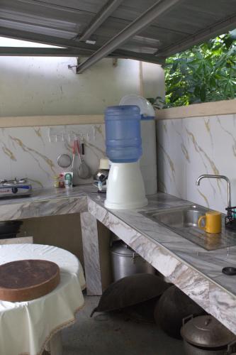 a kitchen counter with a sink and a blue bucket on it at Room 5 in Siquijor