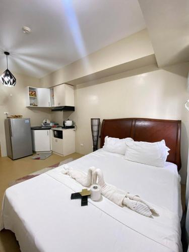 a bedroom with a large white bed with white sheets at 1008 T2 Avida Tower Atria Comfy Cozy in Iloilo City