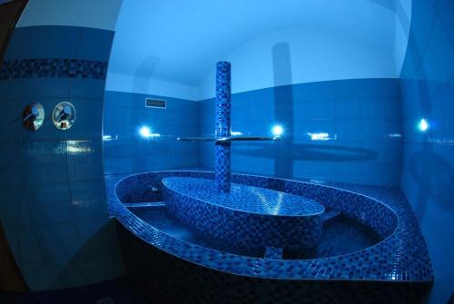 a blue bathroom with a tub with a sink at EA Embassy Prague Hotel in Prague