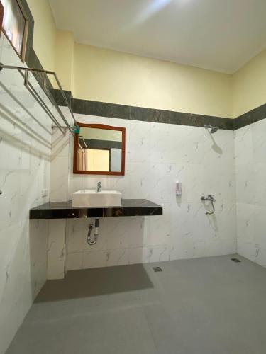 a bathroom with a sink and a mirror on the wall at SADAMA Cottage in Tuktuk Siadong