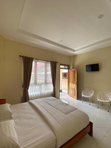 a bedroom with a large bed and a window at SADAMA Cottage in Tuktuk Siadong