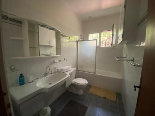 a white bathroom with a sink and a toilet at Beach house within walking distance in La Teste-de-Buch