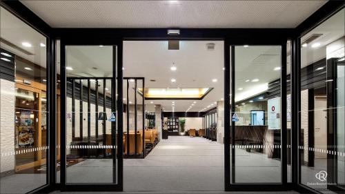 a hallway with glass doors in a building at Daiwa Roynet Hotel Kobe Sannomiya in Kobe