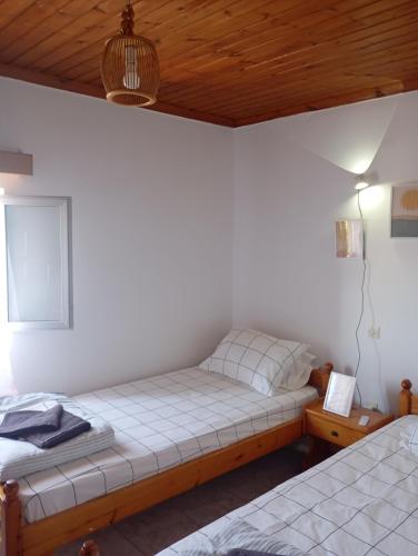 a bedroom with two beds and a wooden ceiling at THE PALM ROOMs in Preveza