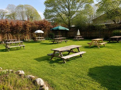 a group of picnic tables in the grass at The George and Dragon Inn in Long Melford