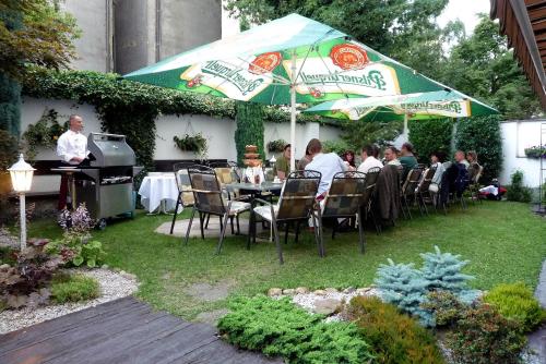 a group of people sitting at a table under an umbrella at Hotel Victoria in Plzeň