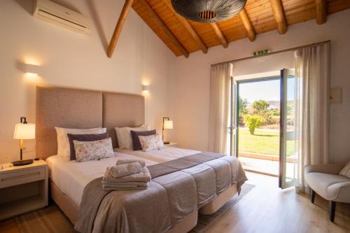 a bedroom with a large bed and a sliding glass door at Quinta da Luz - A Luxury Boutique B&B in Silves