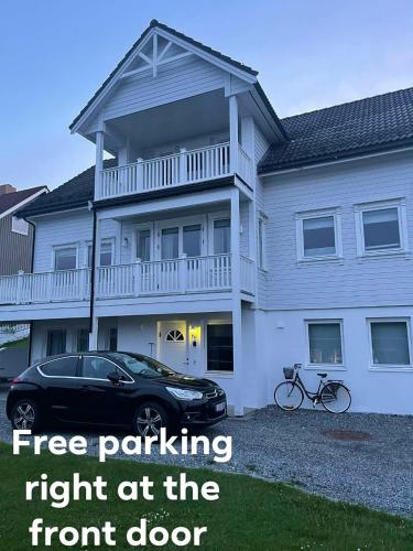 a black car parked in front of a house at Bright & Spacious Apartment by the Sea, Free Parking, 10min to Airport, 12min to Ålesund in Ytterland