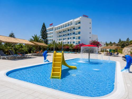 a pool with a slide in the middle of a resort at Corfu Hotel in Ayia Napa