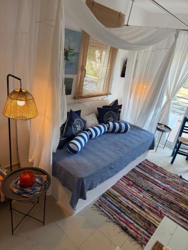 a bedroom with a bed with blue and white pillows at Hara's House 1 in Gerakini