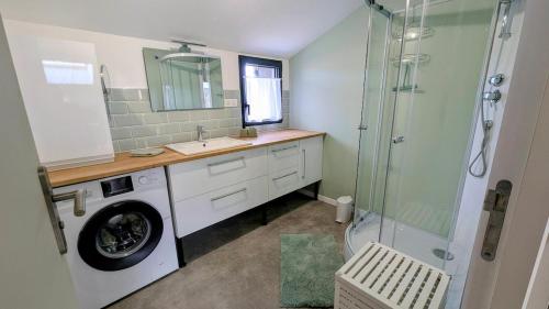 a bathroom with a washing machine and a shower at Appartement in Lorp Sentaraille